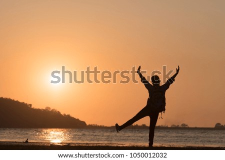 Silhouette freedom girl hand up during sunset beach background