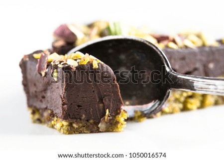 Slice of vegan raw organic healthy chocolate cake with pistachio