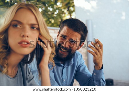 blonde with a man, emotions, criticism                               Royalty-Free Stock Photo #1050023210