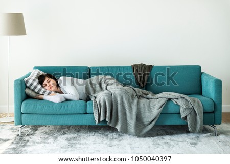 Woman sleeping on the sofa Royalty-Free Stock Photo #1050040397