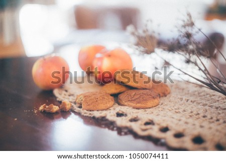 Still life with home made cookies, apples, coffee beans, pot and grounder in village style and brown colors that creates cozy atmosphere of country side house where grandmother lives