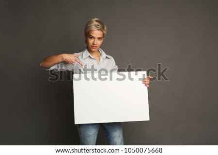 Young woman with blank white paper. Happy girl holding advertising sheet, copy space