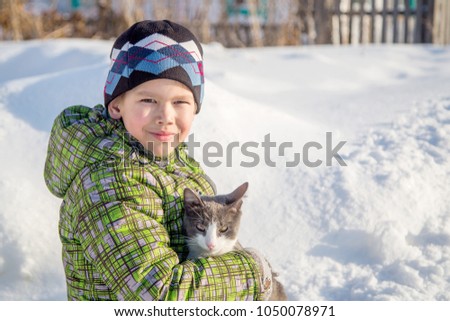 boy with a cat outdoors on a winter day