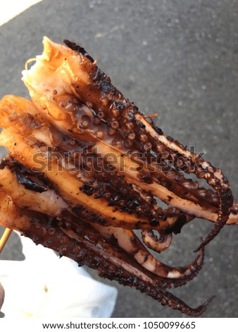 Grilled slice squids on a wood stick in Japan market