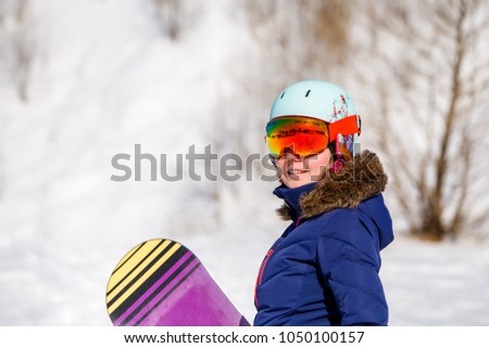 Portrait of sporty woman wearing helmet with snowboard