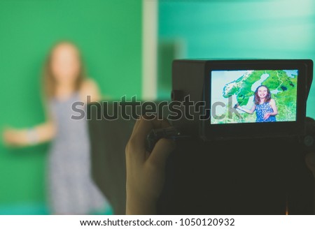 Weather forecast. Little girl standing in front of camera on green screen.