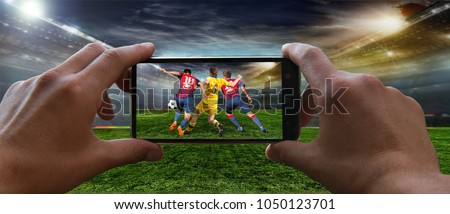 Stadium in the evening in full light before the match.   Football fan removes the football game on mobile phone 2018 