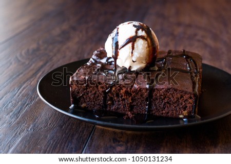 Chocolate Brownie with Ice Cream and Hazelnut Powder. Royalty-Free Stock Photo #1050131234