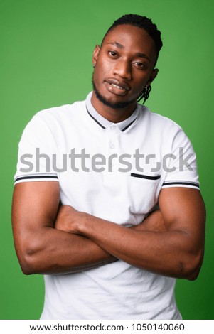 Studio shot of young handsome African man from Kenya against green background