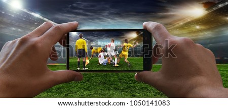 Stadium in the evening in full light before the match.   Football fan removes the football game on mobile phone 2018 