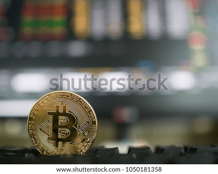 Golden bitcoin coin with Background of stock price table.