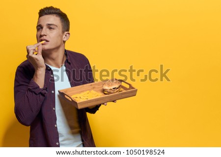 a man eats fast food, a tray                              