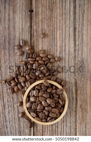 Coffee bean in wooden spoon on woonden table