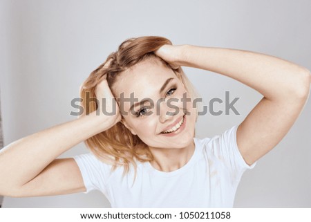 smiling woman holding her hands in her hair                               