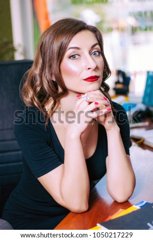 Portrait of a young beautiful girl who sits in the office at the computer desk