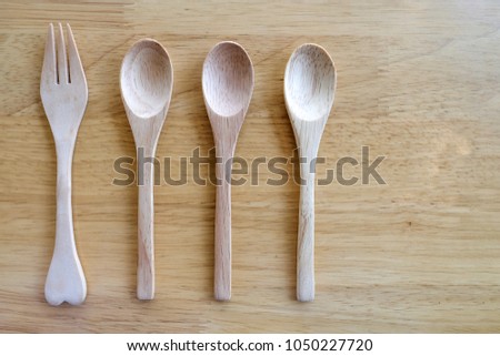 wooden dining utensils made form pinewood, on wooden background, top view, directly above