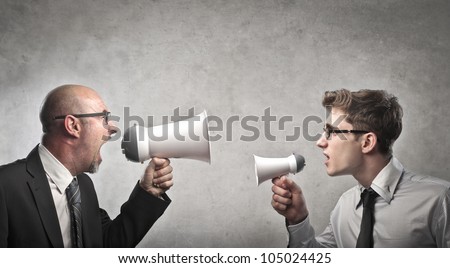 Adult businessman screaming into a megaphone against a younger businessman talking into a smaller one Royalty-Free Stock Photo #105024425