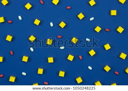 Pattern template with yellow kubes and color tablets on the blue background. 