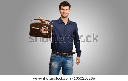 Portrait Of A Man Holding Vintage Radio On Grey Background