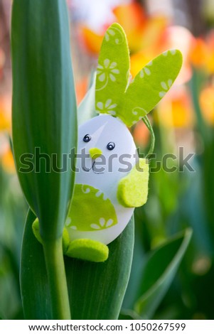 Cute bunny toy hidding among tulips.