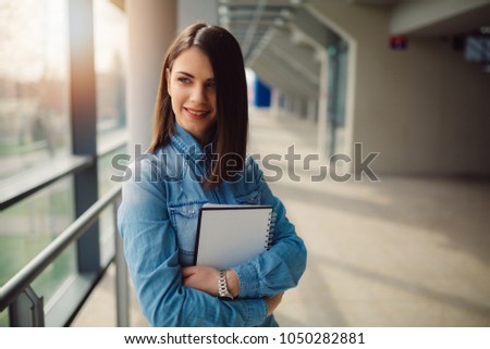 Portrait of a successful business woman holding documents and smiling.