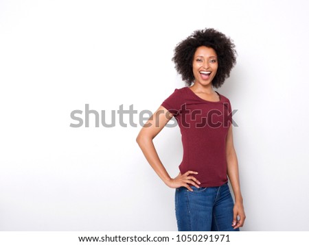 Portrait of confident young woman posing against white background and laughing
