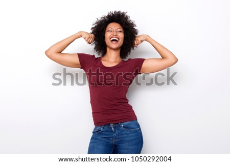 Portrait of healthy young african woman flexing both arms muscles on white background Royalty-Free Stock Photo #1050292004