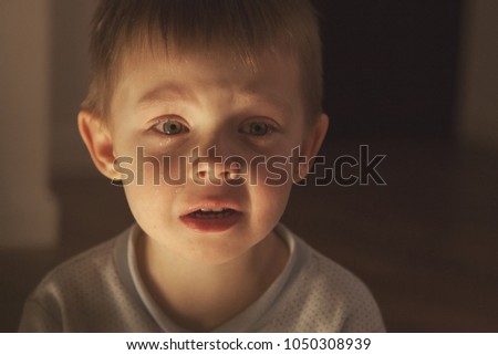The child cries, tears flow from his beautiful light eyes.
