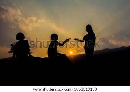 Silhouette group children playing on mountain at sunset time.
