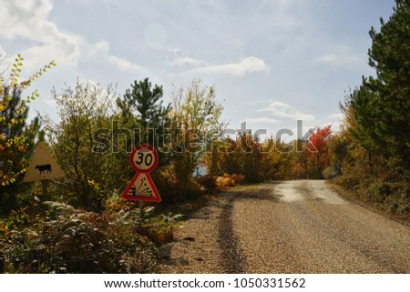 Autum colorful landscape - Asphalt countryside road with road sing.                             