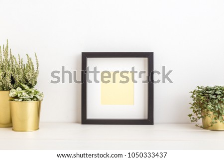 Empty frame and a plants in golden pots. Mock up.
