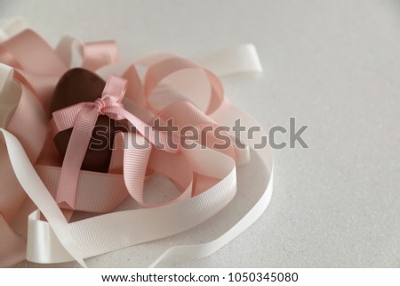 Chocolate Easter eggs with color ribbon bows on the white background.