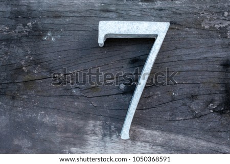 Number 7 (seven) made  from zinc on wood texture background