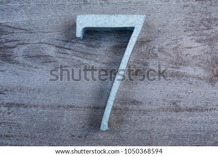 Number 7 (seven) made  from zinc on wood texture background