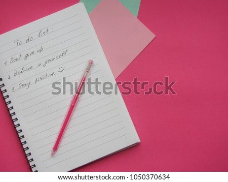 Business lady notebook with positive to do list on the colorful crimson pink background, top view image of open notebook