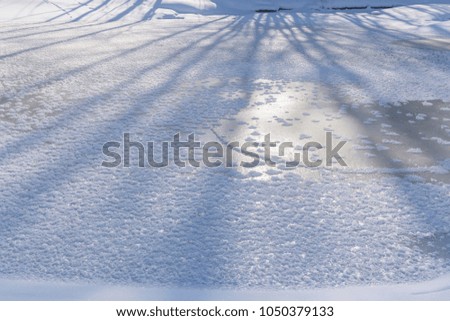 Shadows on the frozen river with sunlight