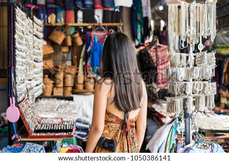 Young woman traveler looking for some souvenir at ubud market in bali Royalty-Free Stock Photo #1050386141