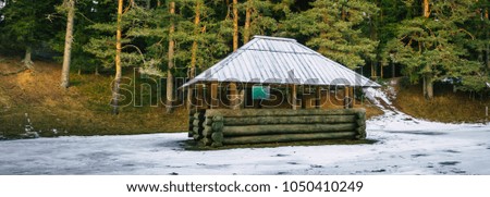 Snow Covered Wooden Gazebo in a Cloudy Winter Day. Translation of text in photo - "Certenes Mound"