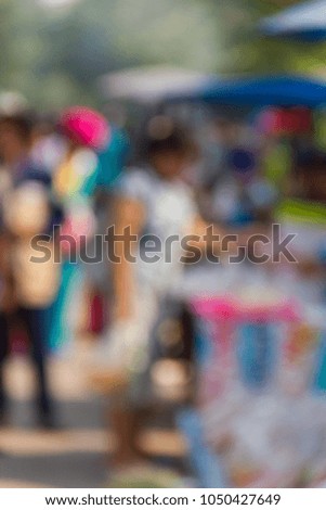 Blurry image of a group people shopping at a flea market in the country