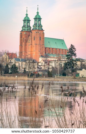 Gniezno, Poland; evening view to the gothic cathedral upon the frozen lake. Winter.