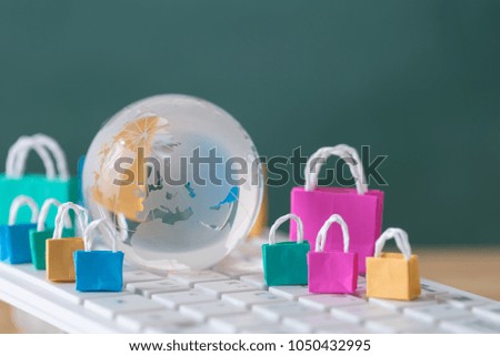 many colorful miniature shopping bags and globe on computer keyboard, online shopping concept