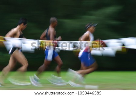 Panning. Blurred. Slow shutter speed. Jogging activities at blurred green tree background