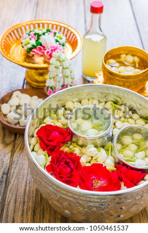 Floating jasmines and roses in silver and golden Thai style dippers, white clay filler, scented water and a garland are used for religious ceremony like Songkran festival