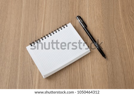 white notebook with a pen on the table
