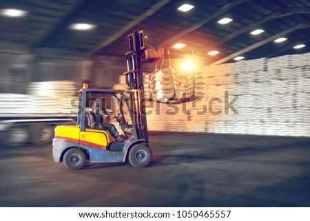 Forklift handling sugar bags from container into warehouse. Distribution, Logistics Import Export, Warehouse operation, Trading, Shipment, Delivery concept. Royalty-Free Stock Photo #1050465557