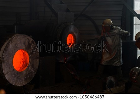 Classic technology of bell producing with melting steel to the ground. Casting new bell for Ebersmunster church in Alsace, France Royalty-Free Stock Photo #1050466487