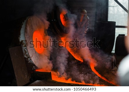 Classic technology of bell producing with melting steel to the ground. Casting new bell for Ebersmunster church in Alsace, France Royalty-Free Stock Photo #1050466493