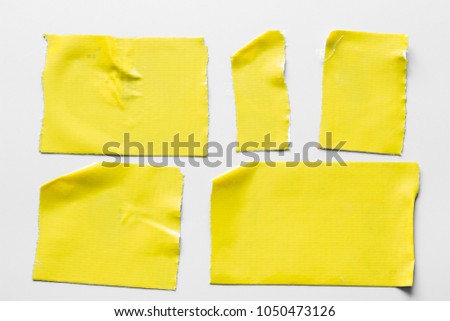 Set of yellow tapes on gray background. Torn horizontal and different size black sticky tape, adhesive pieces.