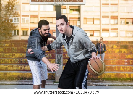 Two male basketball players playing basketball