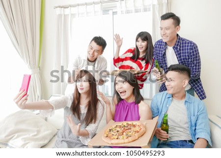 young people eat pizza and selfie happily with party